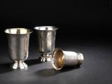 deux tasses en argent posées l'une à côté de l'autre sur une surface noire