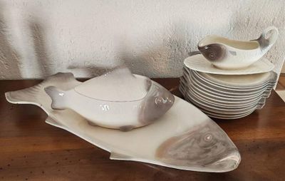 une assiette blanche sur laquelle est représenté un oiseau, à côté d'une assiette sur laquelle est représenté un oiseau