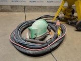 a green helmet and a hose sitting on the floor