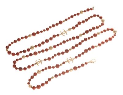 a close up of a long beaded necklace on a white background