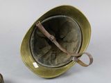 an old military helmet with a leather strap and a pair of scissors