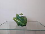 a glass table with a green frog figurine on top of it