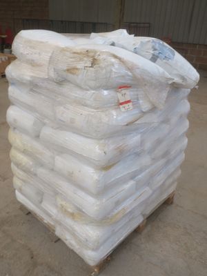 une grande pile de sacs posée sur une palette dans un entrepôt
