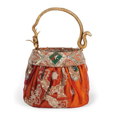 an orange and gold purse with a snake handle on a white background