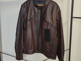 une veste en cuir marron suspendue à un porte-manteau dans une pièce