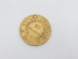 a close up of a gold coin on a white surface