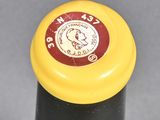 a close up of a bottle of wine with a clock on it