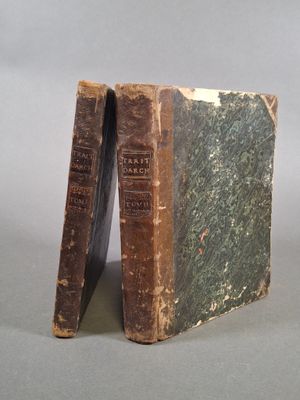 un vieux livre posé sur une table, à côté de deux autres livres