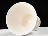 a white cup sitting on top of a white table