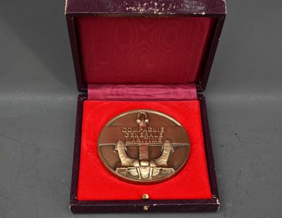 une image représentant une médaille d'or dans un coffret rouge posé sur une table