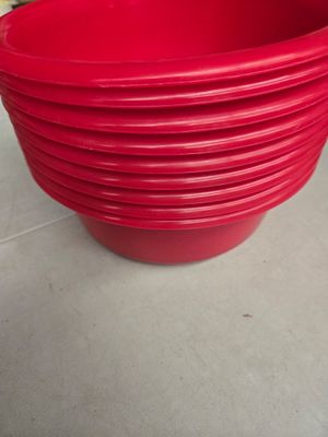 plusieurs bols en plastique rouge empilés les uns sur les autres sur un plan de travail