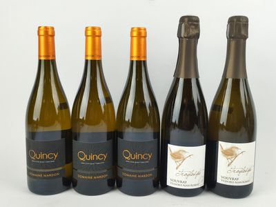 quatre bouteilles de vin sont alignées sur une surface blanche