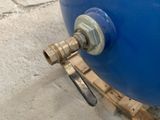 a close up of a blue water tank with a hose attached to it