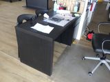 un bureau avec un ordinateur et une chaise dans une pièce