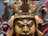 a gold statue of a man with a crown on his head