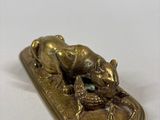 a gold plate with a frog sitting on top of it