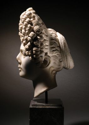 marble bust of a woman with curly hair on a marble base