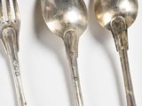 three spoons and a fork on a white surface
