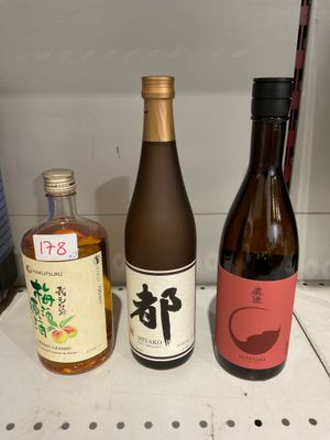 trois bouteilles de vin posées côte à côte sur une étagère