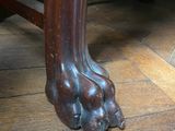 a close up of a wooden table with a dog paw on it
