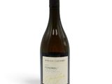 une bouteille de vin blanc posée sur une table blanche