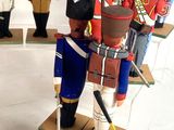 a lot of wooden toy soldiers on display in a room