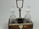 une petite boîte en bois sur laquelle sont posées deux carafes en verre