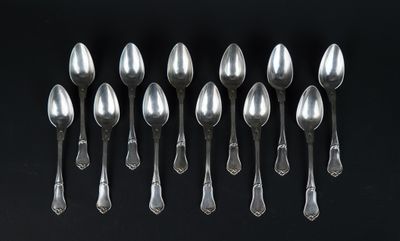 six silver spoons are arranged in a row on a black surface