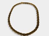 a close up of a gold bracelet on a white background