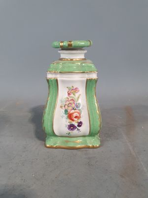 un petit pot vert et blanc orné de fleurs