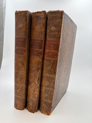 three old books sitting next to each other on a table