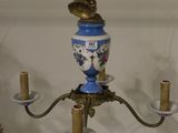 un vase bleu et blanc suspendu à un lustre en laiton