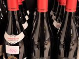 several bottles of wine are lined up on a shelf in a store