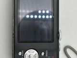 a picture of a digital camera with a cord attached to it
