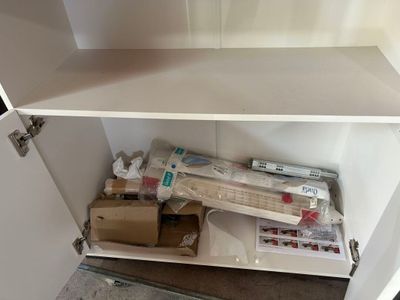 une armoire blanche contenant tout un tas d'objets