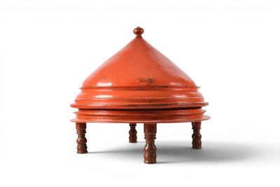 an image of a small red vase sitting on top of a wooden stand