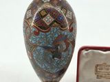 a small vase and a small medal in a case