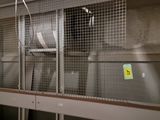 a picture of a room with a metal cage and a window
