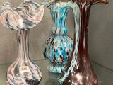 trois vases en verre posés sur une étagère en verre