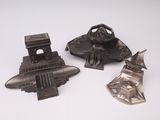 trois objets métalliques posés sur une surface blanche