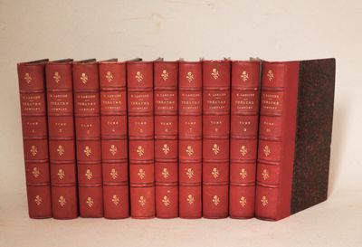 Plusieurs livres rouges sont alignés sur une surface blanche