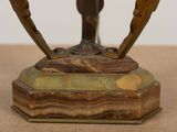 a bronze statue of a bird on a wooden base