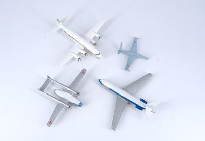 four model airplanes that are sitting on a white surface