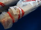 deux sacs de pain emballés dans du plastique, posés sur une surface bleue