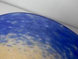 a blue and yellow bowl sitting on a white counter