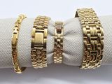 three gold bracelets on a napkin on a white cloth