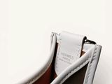 the inside of a white purse with a tag on it