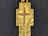 un pendentif en forme de croix en or sur fond noir