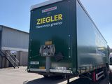 un camion garé sur un parking, avec un homme debout à côté