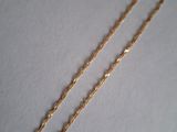 a close up of a gold chain on a white surface